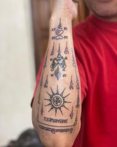 A full arm tattoo in Yantra Sak Yant style